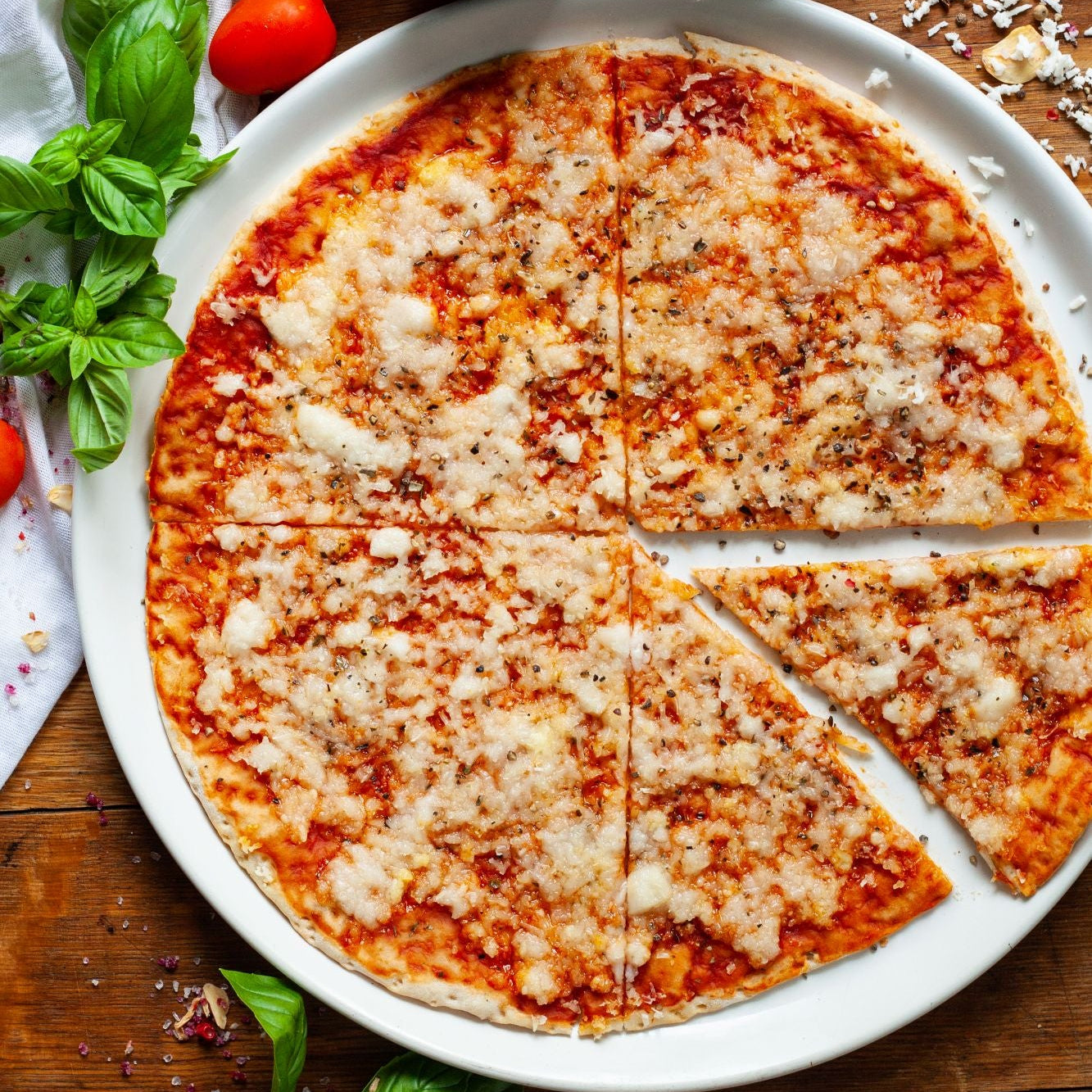 vegan margherita pizza with vegan cheese on a white plate