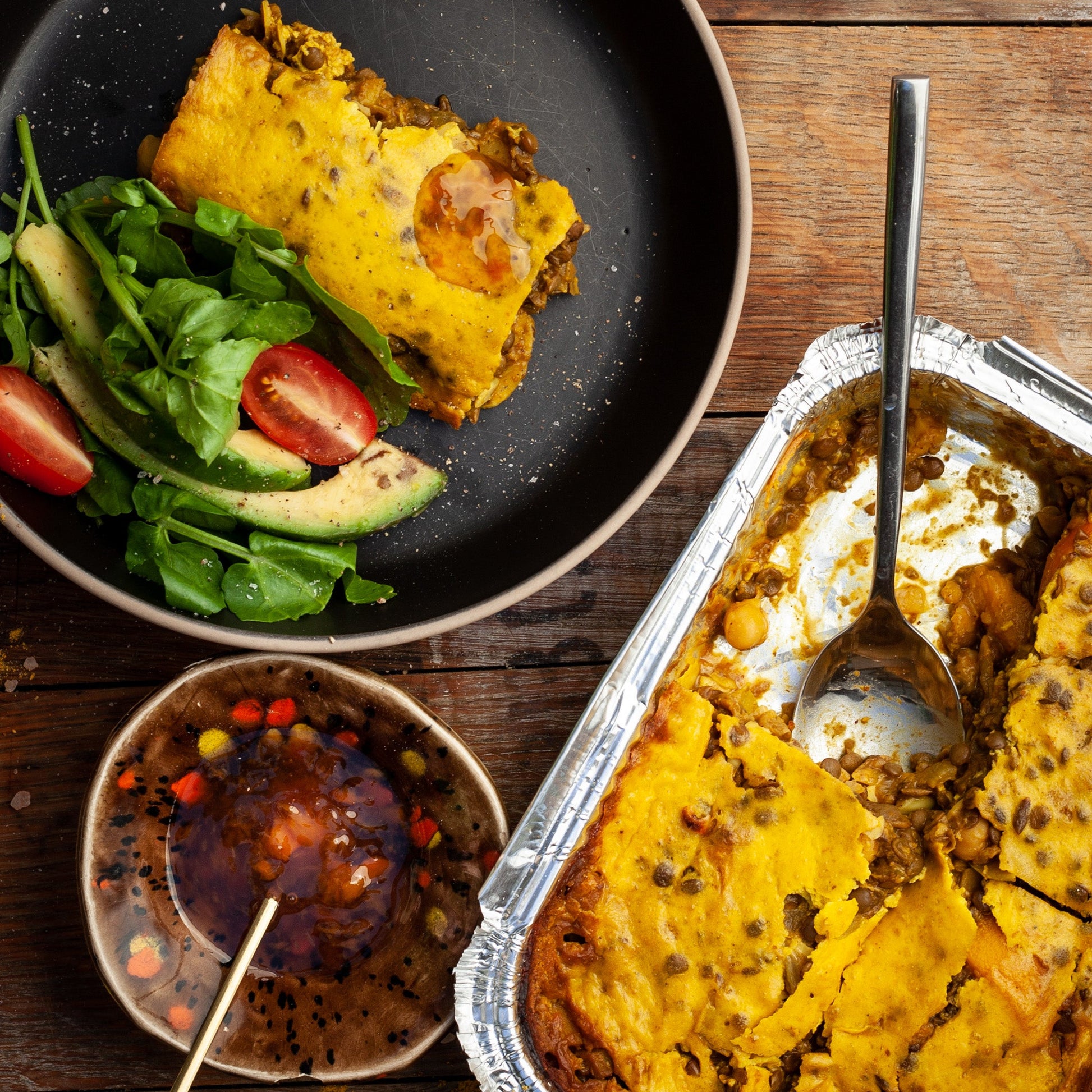 vegan bobotie ready-made meal with a salad, served in a small bowl on a wooden table