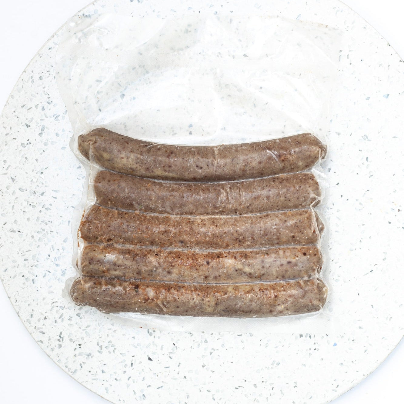 Five vegan boerewors plant-based sausage on a white speckled plate