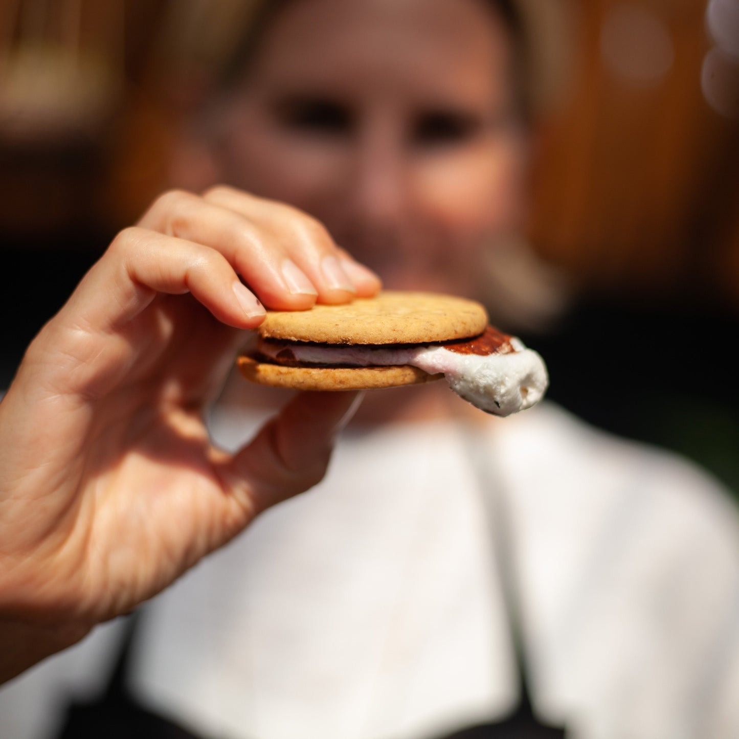 Woman holding a vegan s’more outdoors
